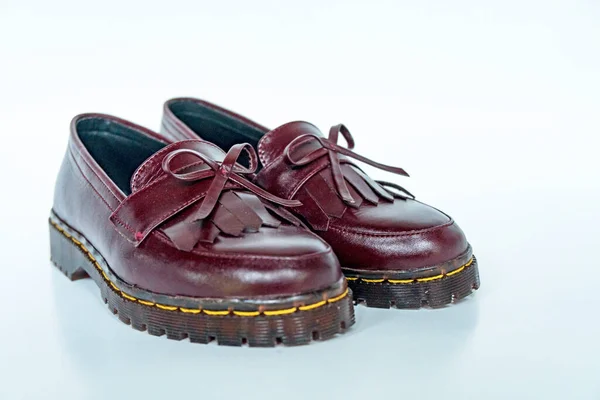 Maroon tassel shoes with rubber soles handcrafted by local craftsmen, photographed on a white background