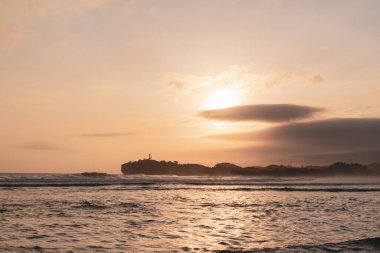 Sadranan Sahili, Endonezya 'da inanılmaz bir gün batımı, onu daha da romantik yapan sisli altın gökyüzü.