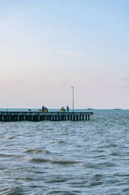 Very wide tropical beach with calm waves during the day with blue sky with clumps of clouds