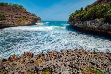 Mercanlar her yere dağılmış beyaz kumsallar. Sular yükselince Gunung Kidul, Endonezya 'da çok güzel, temiz ve ziyaret edilecek ilginç dalgalar var.