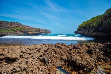 Mercanlar her yere dağılmış beyaz kumsallar. Sular yükselince Gunung Kidul, Endonezya 'da çok güzel, temiz ve ziyaret edilecek ilginç dalgalar var.
