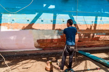 The process of patching the hull of the Bagan boat which is usually used by fishing groups to find fish in the middle of the Kalimantan sea, this process is carried out together