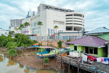 Nehrin aşağısında, deniz kıyısında ve kentsel alanlarda yer alan balıkçı köyü, kahverengi nehir suyuyla biraz köhne ve sağlıksız görünüyor.