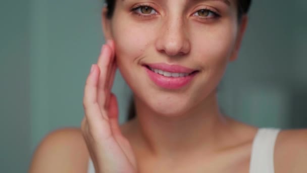 Flickan gör en ansiktsmassage. Flickan jämnar ut huden i ansiktet. Närbild. — Stockvideo