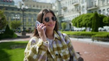 Gülümseyen bir kız telefona cevap verir ve parkta telefonla konuşmaya başlar. Sokakta yüzünde bir gülümsemeyle cep telefonuyla konuşan bir kız. Genç kız onunla dostça sohbet ediyor.