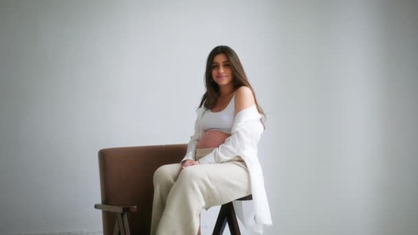 Pregnant Girl Sits Chair White Background Poses Camera Pregnant Young — Wideo stockowe