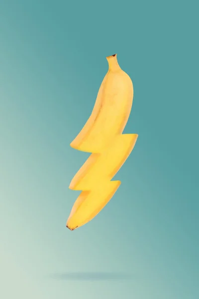 Fresh yellow banana isolated on blue background. Element of energy icons. Banana enegy food. Fruit concept. Flying banana. Energy, sport, breakfast. Food creative concept. creative thunder icons.