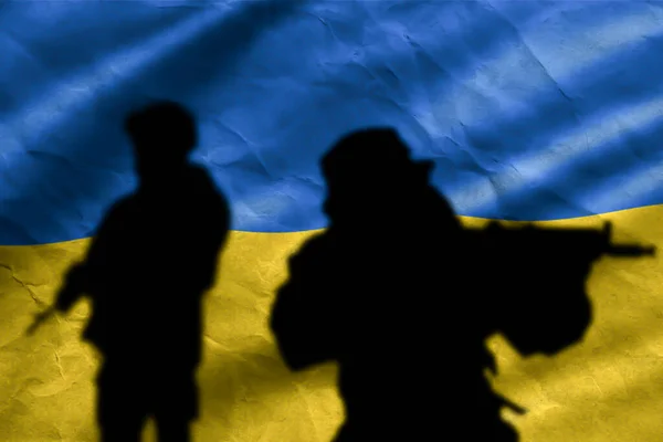 Conceptual image of war between russia and Ukraine with shadow of two soldier against the background of the flag of Ukraine. Wall with national flag crumpled kraft background paper texture.