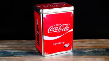 Vintage Coca-Cola Storage Tin on Black Background on painted wooden desk