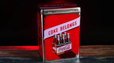 Vintage Coca-Cola Storage Tin on Black Background with red accent on a wooden table