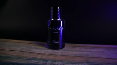 Dior Sauvage Parfüm Şişe Kırsal boyalı masa üzerinde mavi aksanlı ışıklandırma