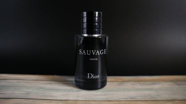Dior Sauvage Parfüm Şişe boyalı ahşap masa ve siyah arka plan