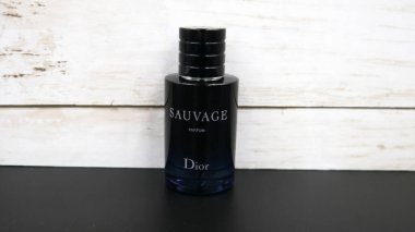 Dior Sauvage Parfüm Şişe profili beyaz ahşap arka planlı siyah masa üzerinde