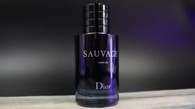Dior Sauvage Parfüm Şişe ahşap bir masa üzerinde mavi ışıklandırmalı