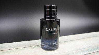 Dior Sauvage Parfüm Şişe Kırsal boyalı masa üzerinde mavi aksanlı ışıklandırma