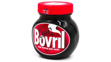 Beyaz arka planı olan beyaz ahşap bir masada bir kavanoz Bovril