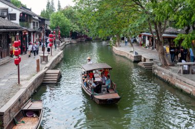 Şangay, Çin - Eylül 2019: Çin 'in Qingpu Bölgesi' nde tarihi bir köy ve ünlü bir turizm beldesi olan Zhujiajiao Antik Su Kasabası 'ndaki kanal boyunca geleneksel Çin kayığıyla gezi turu