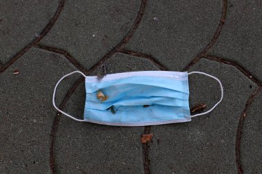 Coronavirus 'a karşı korunmak için kullanılan eski bir tıbbi maske (covid-19) İsrail' deki bir şehir parkında yatıyor. İsrail 'de beşinci Coronavirüs dalgası 