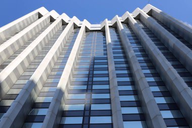 Mavi gökyüzüne karşı büyük bir şehirde yüksek binaların alt manzarası. 