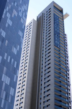 Mavi gökyüzüne karşı büyük bir şehirde yüksek binaların alt manzarası. 