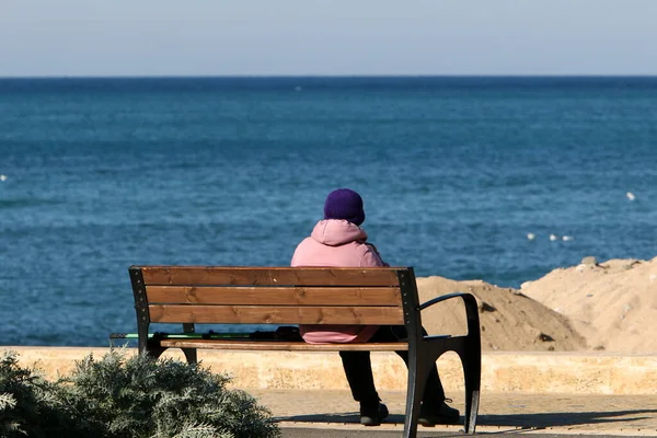 Akdeniz kıyısındaki bir şehir parkında bankta. 