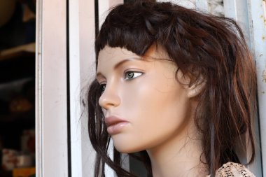 A mannequin stands on a showcase in a store. 