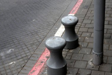 Fencing along the road to separate the carriageway from the sidewalk. 