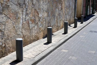 Fencing along the road to separate the carriageway from the sidewalk. 