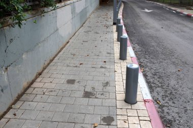 Fencing along the road to separate the carriageway from the sidewalk. 