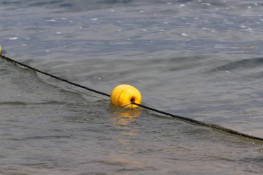 A rope with floats on the city beach enclosing safe swimming areas. 