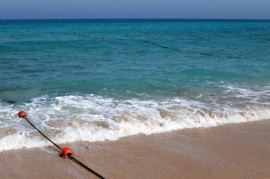 A rope with floats on the city beach enclosing safe swimming areas. 