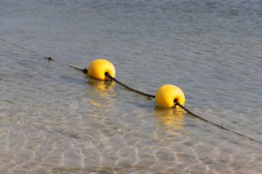 A rope with floats on the city beach enclosing safe swimming areas. 