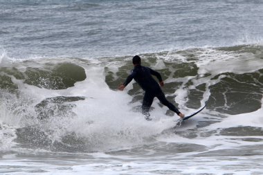 Surfing on high waves in the Mediterranean.
