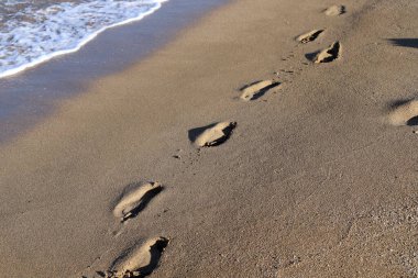Footprints in the sand on the shores of the Mediterranean Sea.