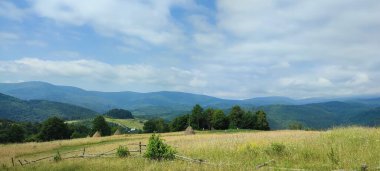 Dağları ve mavi gökyüzü olan güzel bir manzara.