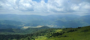 Dağları ve mavi gökyüzü olan güzel bir manzara.