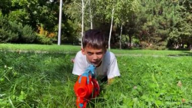 A boy playing with his nerf gun at the park. 