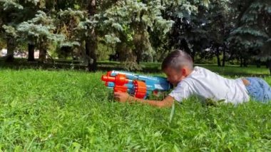 A boy playing with his nerf gun at the park. 