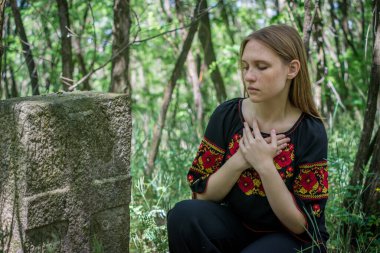 Trakhtemirov köyündeki eski bir Kotsatsky mezarının yanında geleneksel Ukraynalı elbiseli güzel bir genç kız..