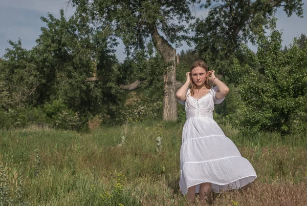 在特拉赫特米罗夫村的三叉树旁 一位身穿乌克兰传统白衣的美丽的乌克兰少女在田里玩耍 — 图库照片