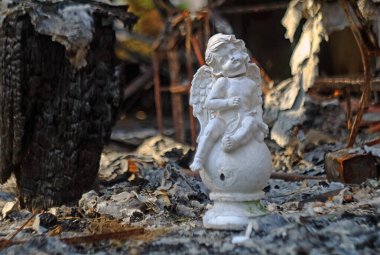 Bucha city Kiev region. A house burned down after being hit by a Russian shell. Statue of the Guardian Angel with its head broken off in front of the burnt-out house.