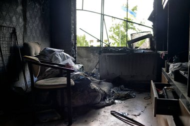 A flat in the town of Borodyanka after being hit by a shell. A burned electric cooker, cracked wall and ashes from furniture, burnt flowers and children's shoes.