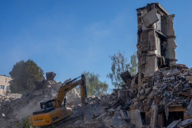 Gostomel, Kyiv Ukrayna - 25 Eylül. 2022: Bir kazıcı kovayla bir evi yok etti. Ev, Rus birlikleri tarafından işgal sırasında hasar gördü ve bir bomba tarafından vuruldu.. .
