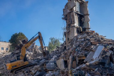 Gostomel, Kyiv Ukrayna - 25 Eylül. 2022: Bir kazıcı kovayla bir evi yok etti. Ev, Rus birlikleri tarafından işgal sırasında hasar gördü ve bir bomba tarafından vuruldu.. .