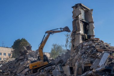 Gostomel, Kyiv Ukrayna - 25 Eylül. 2022: Bir kazıcı kovayla bir evi yok etti. Ev, Rus birlikleri tarafından işgal sırasında hasar gördü ve bir bomba tarafından vuruldu.. .