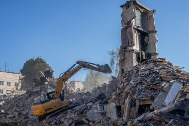 Gostomel, Kyiv Ukrayna - 25 Eylül. 2022: Bir kazıcı kovayla bir evi yok etti. Ev, Rus birlikleri tarafından işgal sırasında hasar gördü ve bir bomba tarafından vuruldu.. .