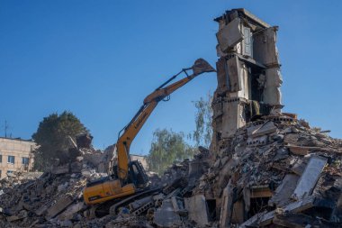 Gostomel, Kyiv Ukrayna - 25 Eylül. 2022: Bir kazıcı kovayla bir evi yok etti. Ev, Rus birlikleri tarafından işgal sırasında hasar gördü ve bir bomba tarafından vuruldu.. .