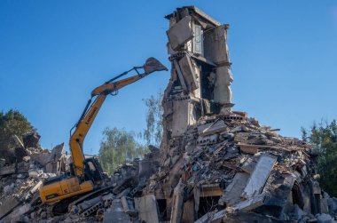 Gostomel, Kyiv Ukrayna - 25 Eylül. 2022: Bir kazıcı kovayla bir evi yok etti. Ev, Rus birlikleri tarafından işgal sırasında hasar gördü ve bir bomba tarafından vuruldu.. .