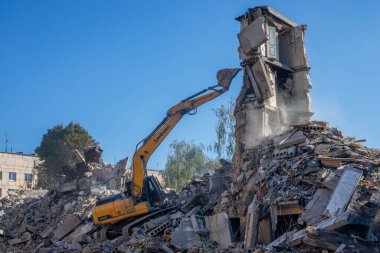 Gostomel, Kyiv Ukrayna - 25 Eylül. 2022: Bir kazıcı kovayla bir evi yok etti. Ev, Rus birlikleri tarafından işgal sırasında hasar gördü ve bir bomba tarafından vuruldu.. .