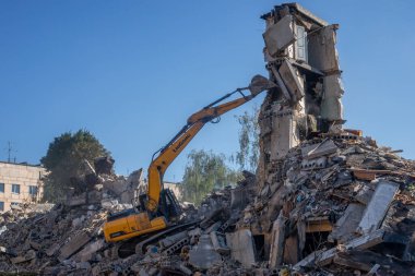 Gostomel, Kyiv Ukrayna - 25 Eylül. 2022: Bir kazıcı kovayla bir evi yok etti. Ev, Rus birlikleri tarafından işgal sırasında hasar gördü ve bir bomba tarafından vuruldu.. .